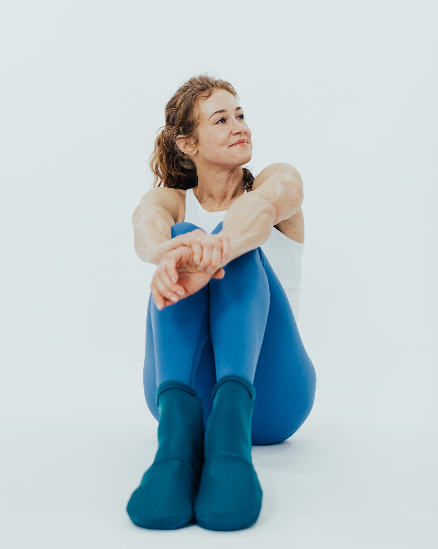 Woman wearing iGel cold therapy socks while relaxing on the floor